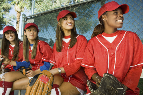 Wall Mural Multiethnic baseball players sitting in a line looking away