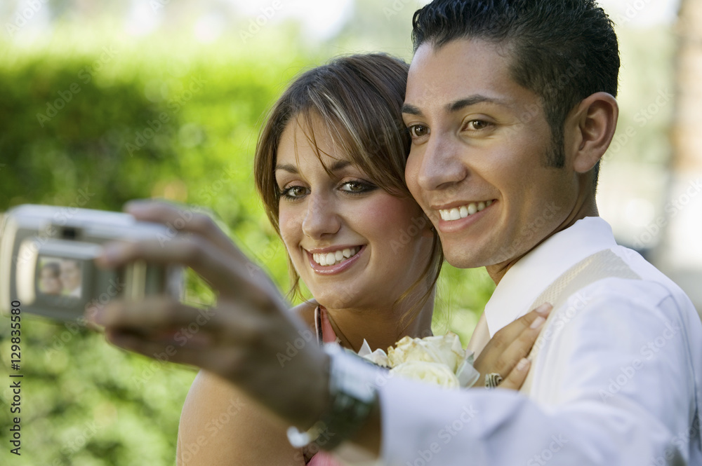 Well-dressed teenage couple taking photograph outside Well-dressed teenage couple taking photograph outside