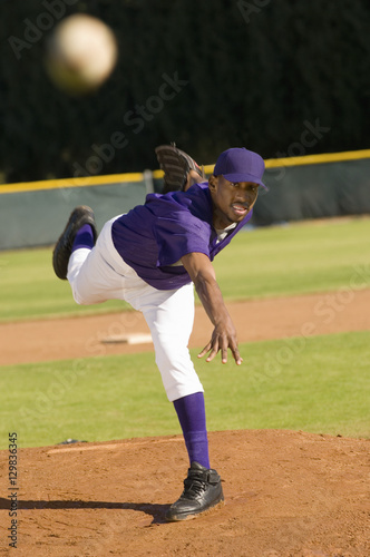 Young African American baseball pitcher throwing the ball