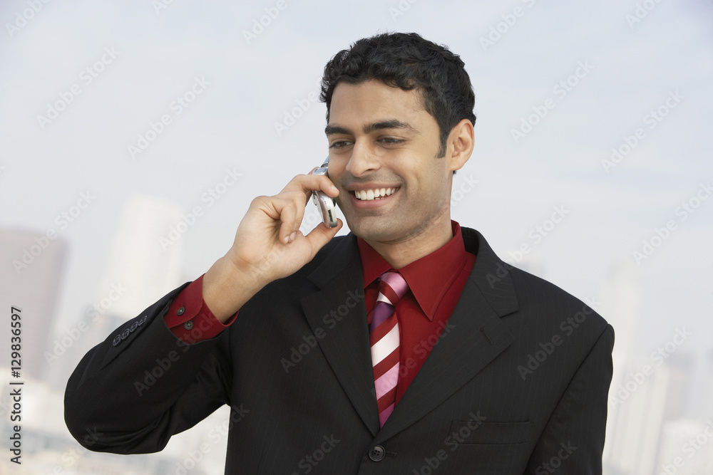 Young smiling mixed race businessman using mobile phone Young smiling mixed race businessman using mobile phone