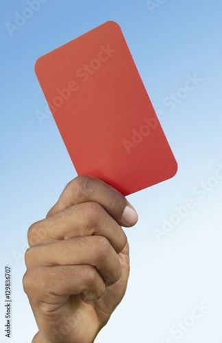 Soccer referee holding up red card close-up on hand