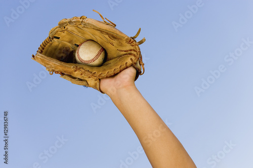 Photography Hand of baseball player with glove and ball against clear sky