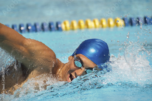 Wall Mural Male participant swimming in a freestyle during swimming race