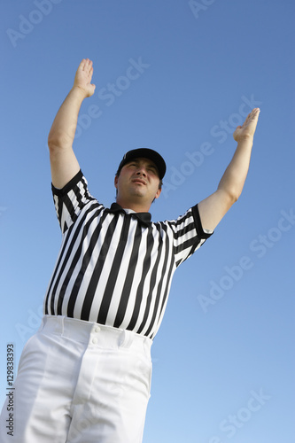 Low angle view of referee gesturing homerun against clear sky