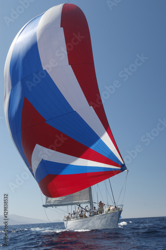 Boat with colorful sail in yacht race against the clear blue sky