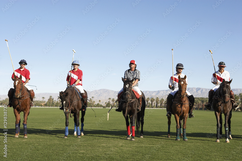 Polo players and umpire mounted on horses on field Polo players and umpire mounted on horses on field