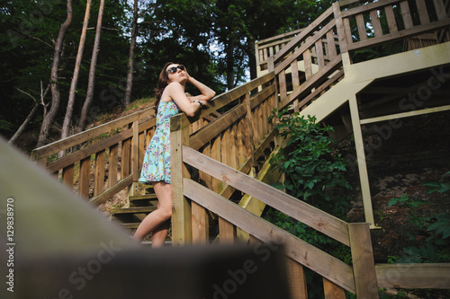 girl sitting on the wooden stairs in park and smiling