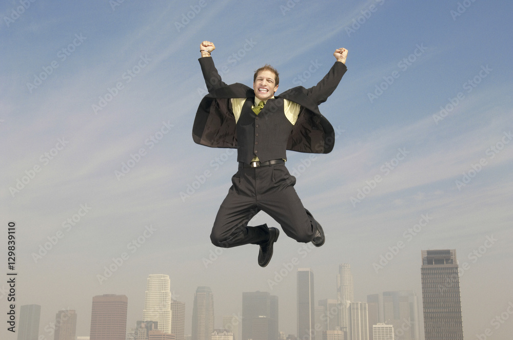 Full length of young businessman jumping in joy above city Full length of young businessman jumping in joy above city