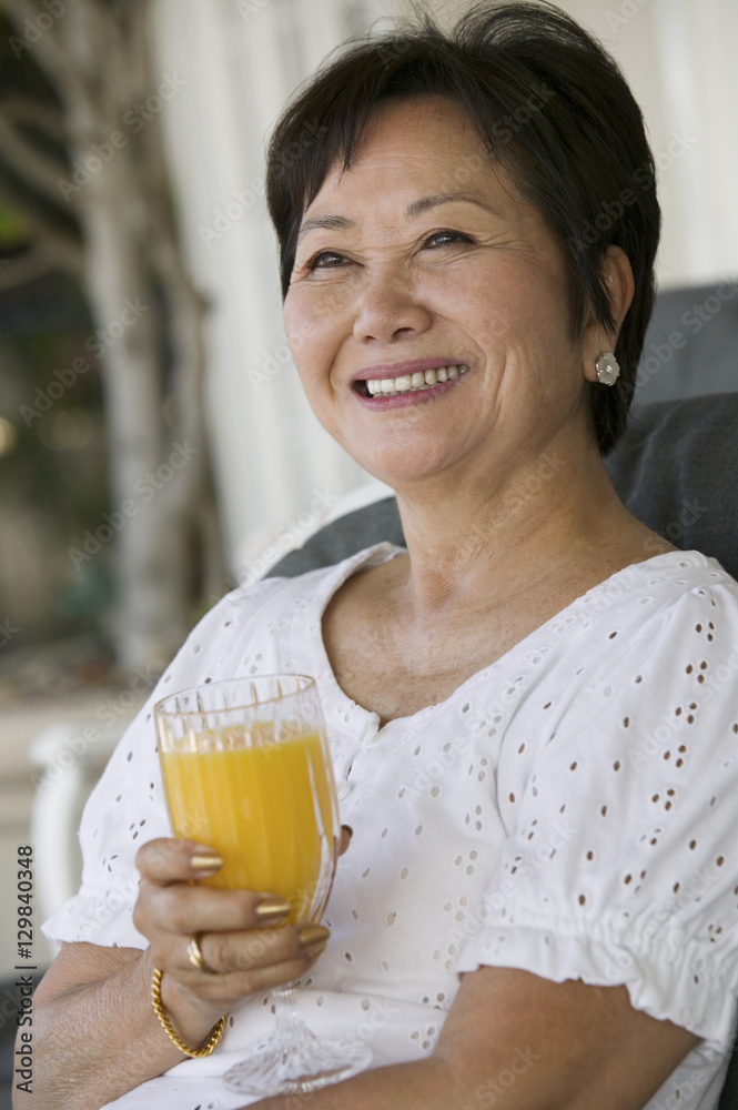 Woman drinking orange juice smiling outdoors Woman drinking orange juice smiling outdoors