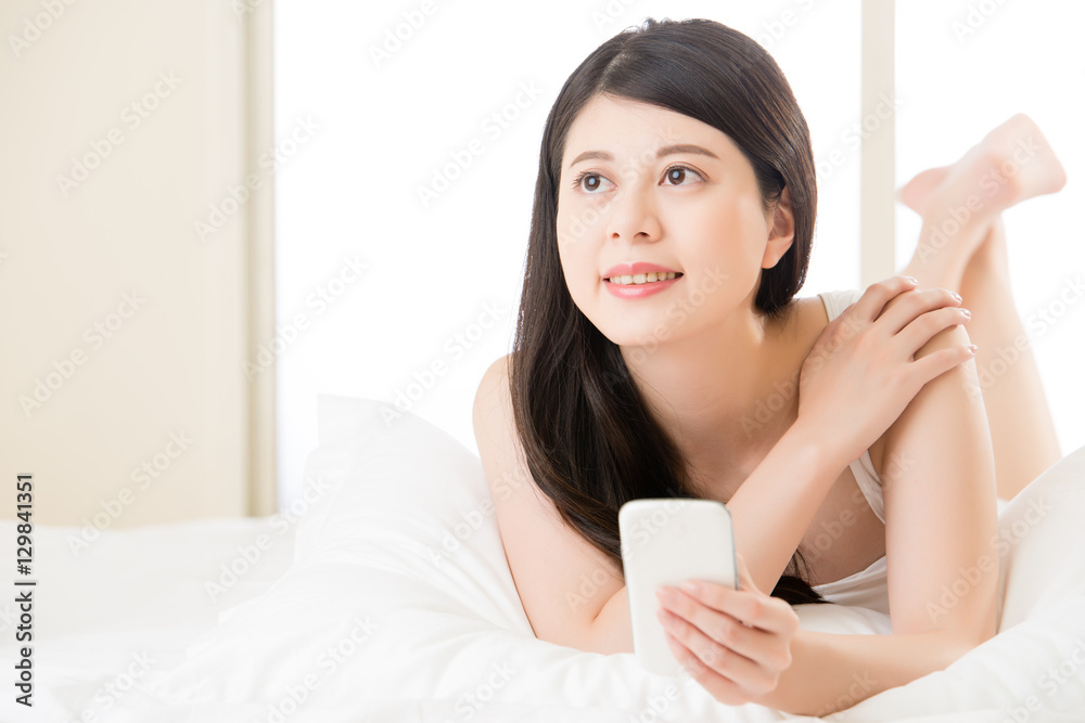 Young asian woman reading use smart phone on bed Young asian woman reading use smart phone on bed