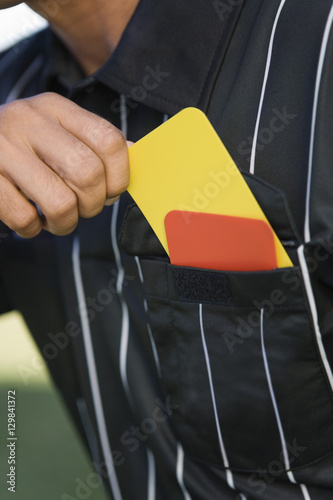 Closeup midsection of a referee taking card from his pocket