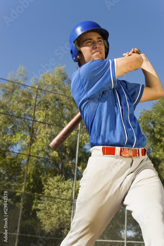 Canvas Print Young male player swinging baseball bat