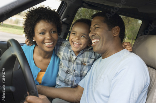 Cheerful little boy and parents sitting in car © moodboard