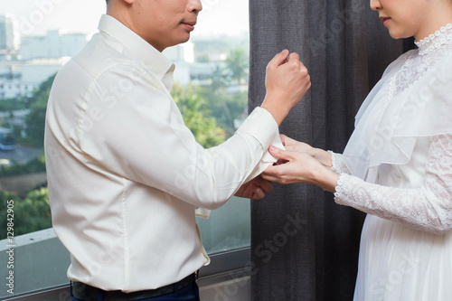Women help men buttoned sleeves