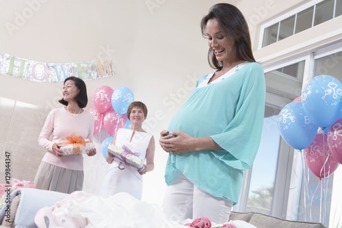 Cheerful pregnant woman with friends at a baby shower