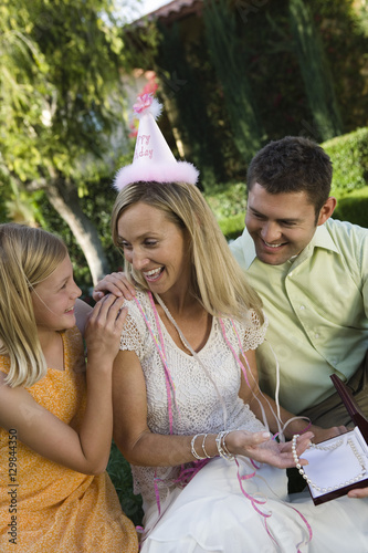 Happy mother showing gift to her daughter at birthday