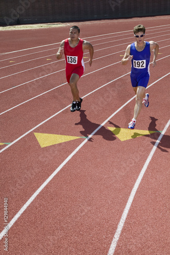 Two male athletes running on race track © moodboard