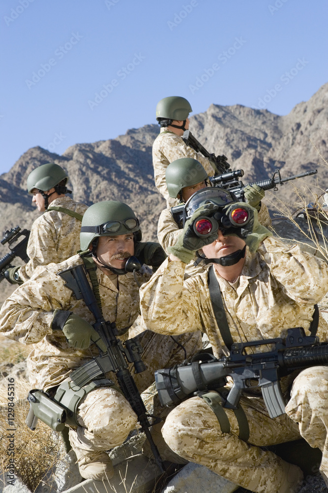 Fototapeta premium Group of soldiers with rifles and binocular patrolling during war