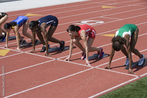 Group of female athletes at start of running track