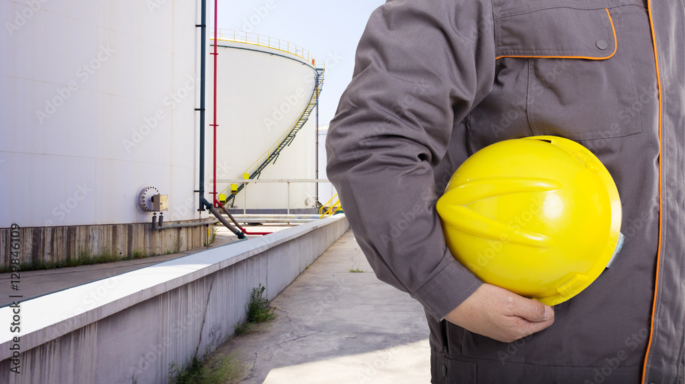Fototapeta premium man engineer with helmet and oil tanks