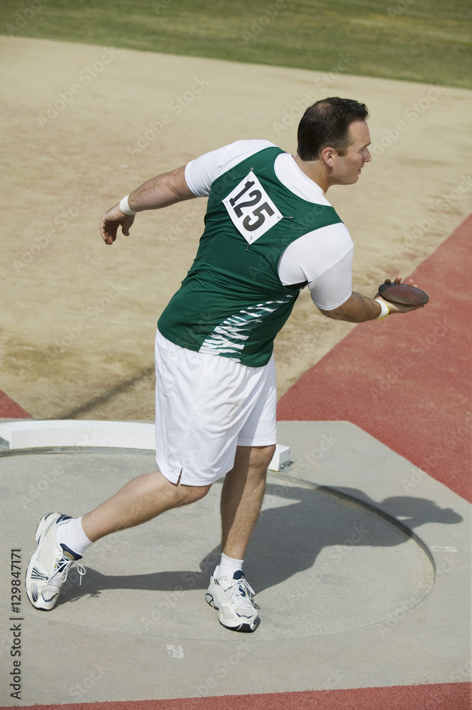 Full length of athletic man preparing to throw discus