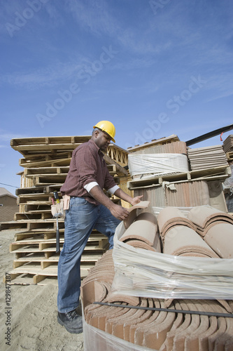 Manual worker picking a tile at construction site