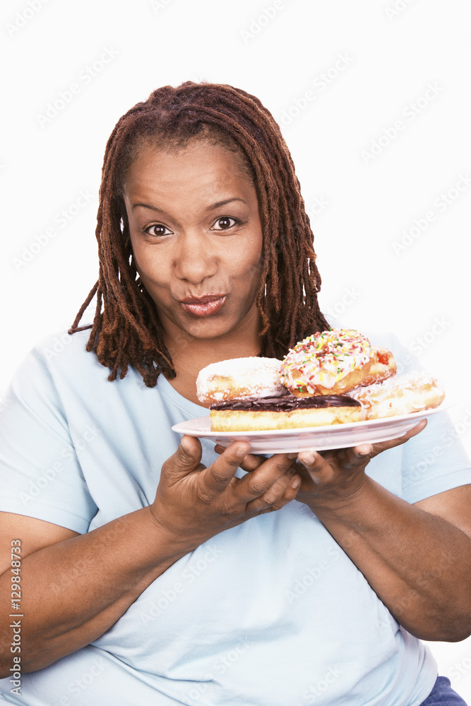 Portrait of obese woman holding plate of donuts isolated over white background Portrait of obese woman holding plate of donuts isolated over white background