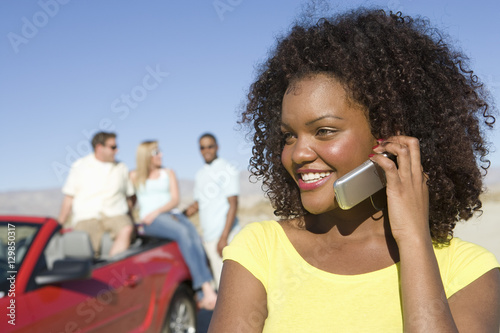 An African American happy woman on a call with friends in the background