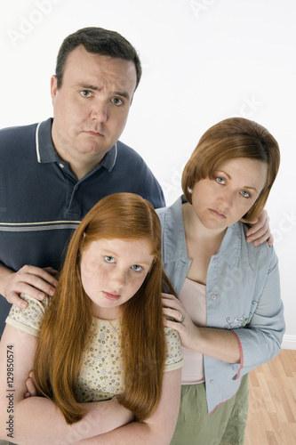 Portrait of unhappy family standing together