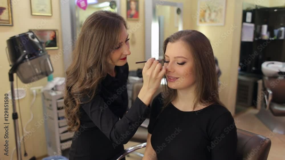 A professional make-up artist doing make-up for the girl. Beauty salon. Beautiful woman face. Perfect make-up. A professional make-up artist doing make-up for the girl. Beauty salon. Beautiful woman face. Perfect make-up.