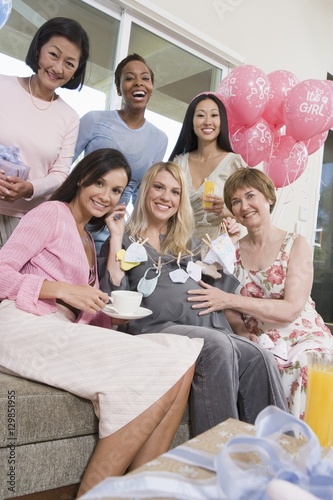 Group of diverse friends with pregnant woman at a baby shower