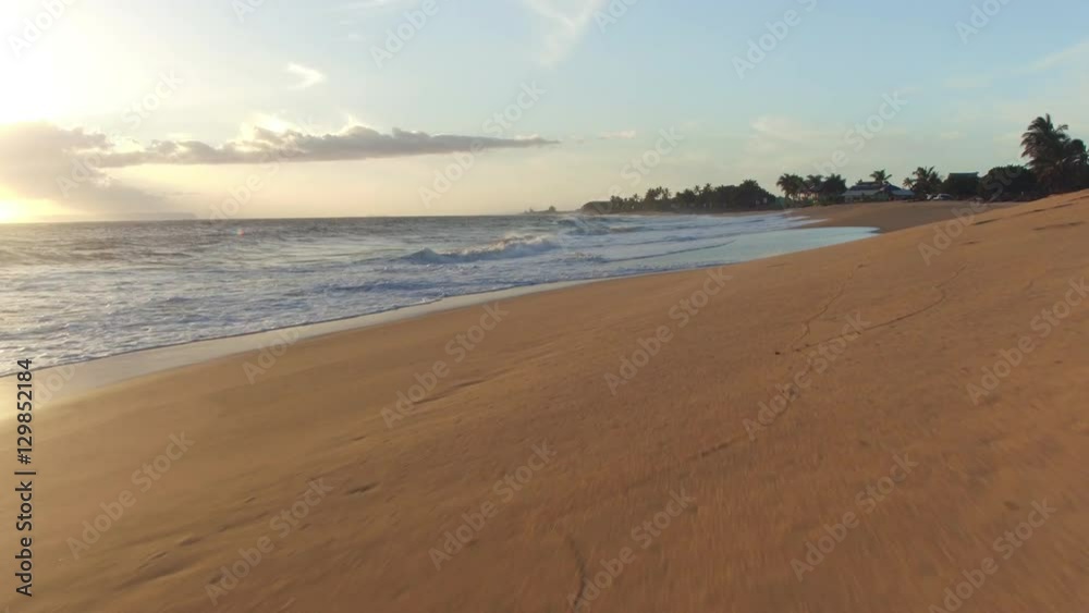 AERIAL: Beautiful ocean waves washing smooth sandy beach along the coastal road AERIAL: Beautiful ocean waves washing smooth sandy beach along the coastal road