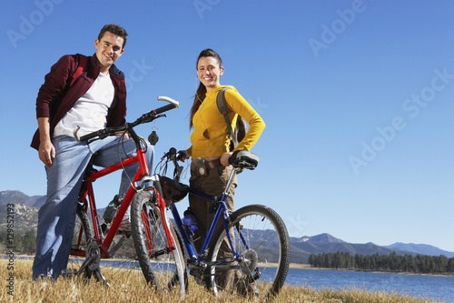 Full length portrait of Caucasian couple standing with their bicycles