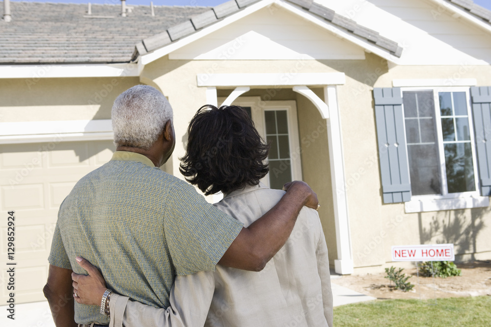 Φωτογραφία Rear view of African American couple standing in front of new house