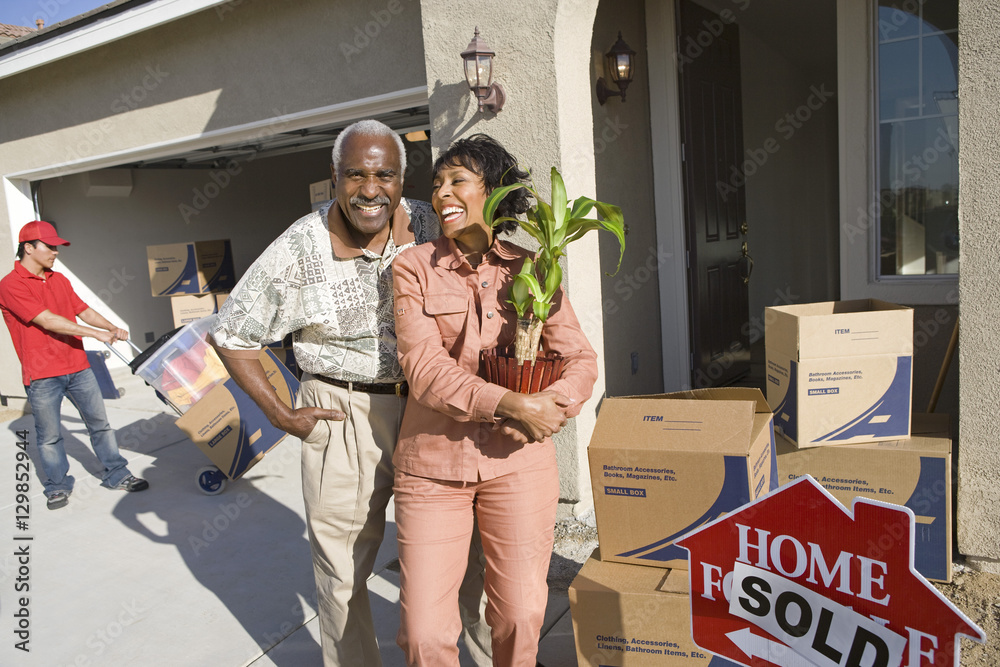 Φωτογραφία Cheerful African American couple with belongings moving into a new house