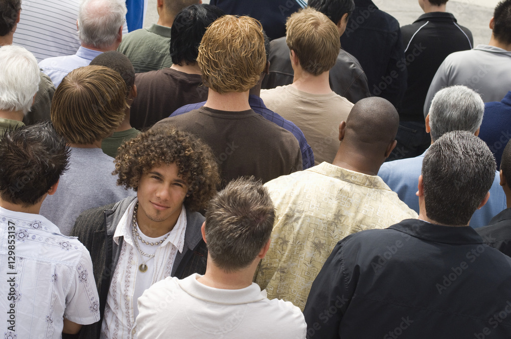 Portrait of young man surrounded by multiethnic men Portrait of young man surrounded by multiethnic men