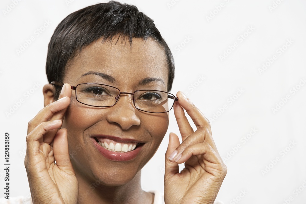 Close-up portrait of an African American woman trying on eye glasses over white background Close-up portrait of an African American woman trying on eye glasses over white background