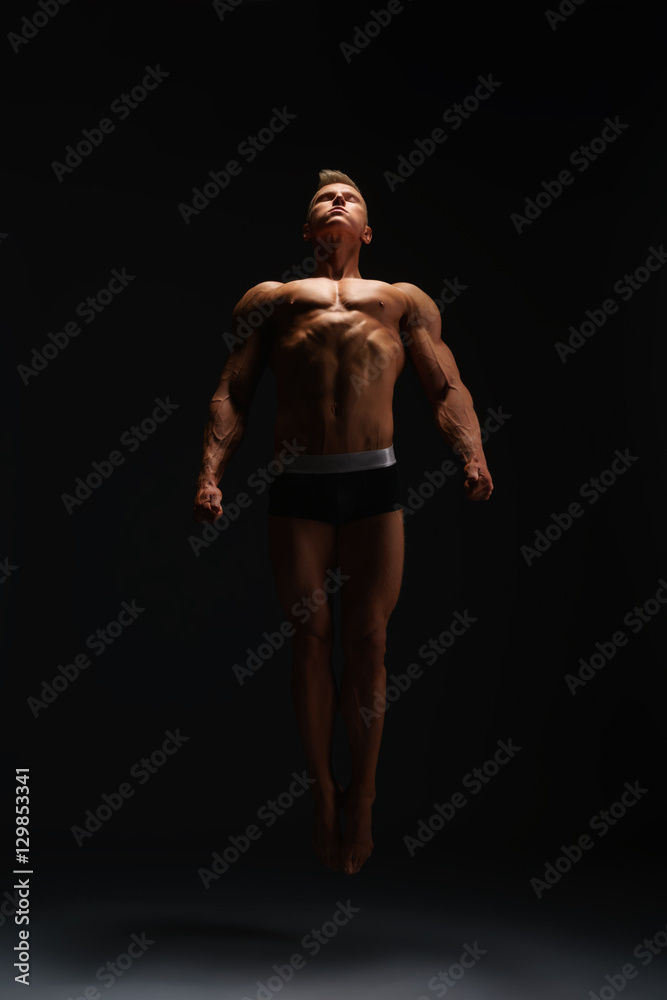Muscular bodybuilder posing on black background. Muscular bodybuilder posing on black background.