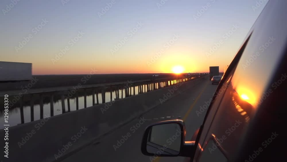 Close up personal car driving on busy highway at beautiful summer sunset