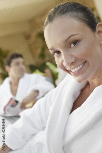 Portrait of a happy mature woman with man sitting in the background