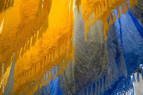 Brightly coloured dyed fabrics hanging to dry in the dyers souk, Marrakech, Morocco photo