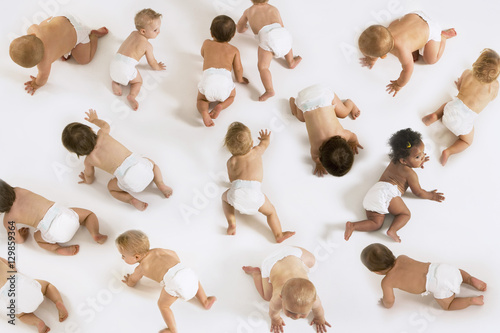 Group of multiethnic babies crawling isolated on white background photo