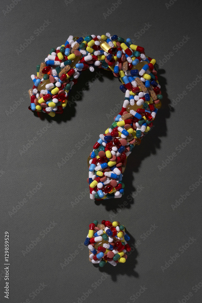 Various pills forming question mark on black background Various pills forming question mark on black background