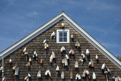 Painted wooden buoys on a shingled building in Sag Harbor, Long Island, New York State