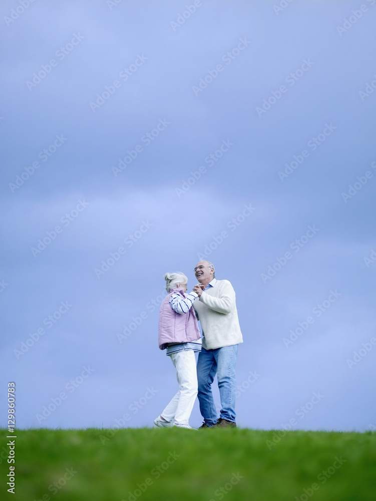 Full length of happy senior couple dancing on field Full length of happy senior couple dancing on field