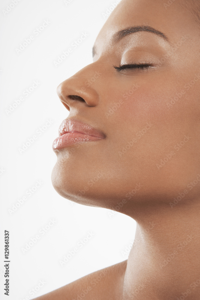 Closeup of beautiful young African American woman with eyes closed isolated on white background Closeup of beautiful young African American woman with eyes closed isolated on white background