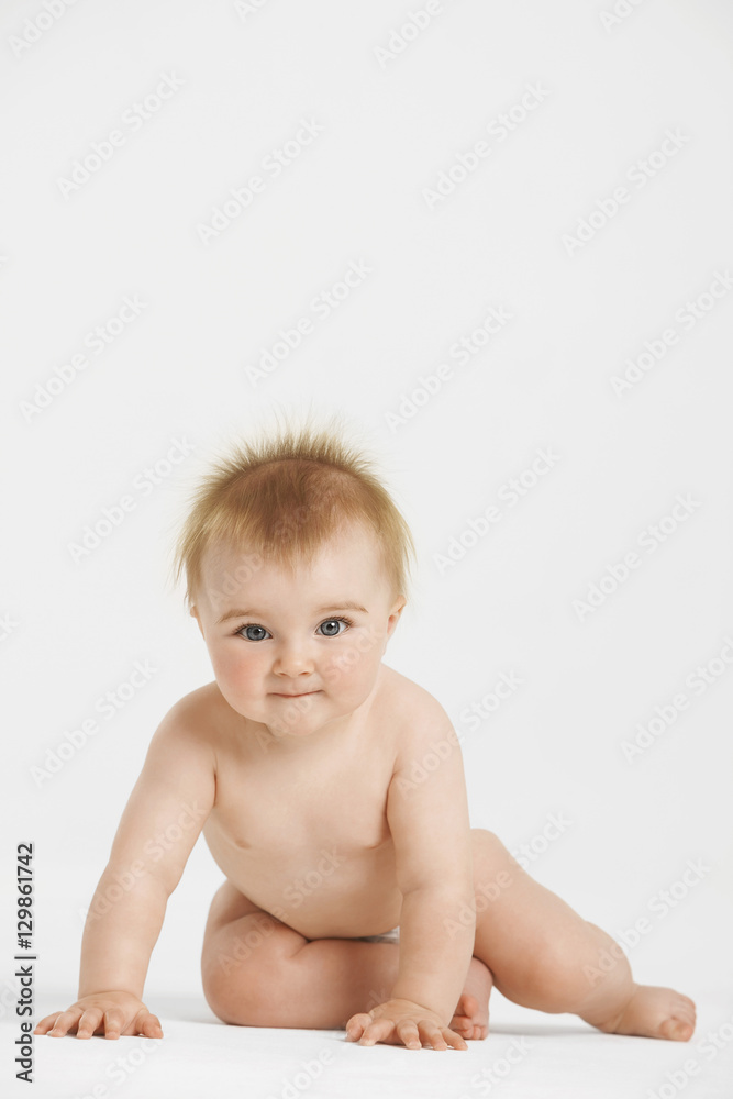 Full length portrait of cute baby with redhead sitting isolated on white background Full length portrait of cute baby with redhead sitting isolated on white background
