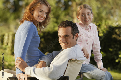 Portrait of happy parents with daughter in backyard