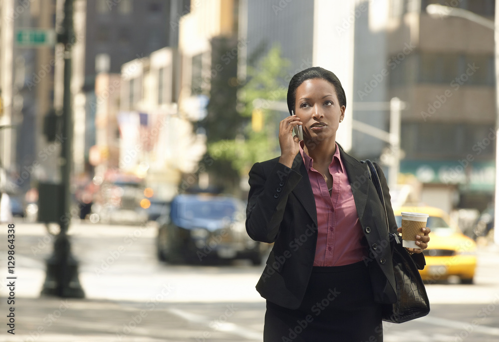 Serious African American businesswoman using mobile phone on street Serious African American businesswoman using mobile phone on street