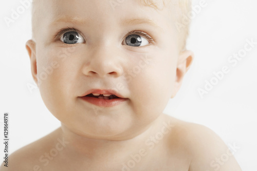 Closeup of cute baby with blue eyes isolated on white background